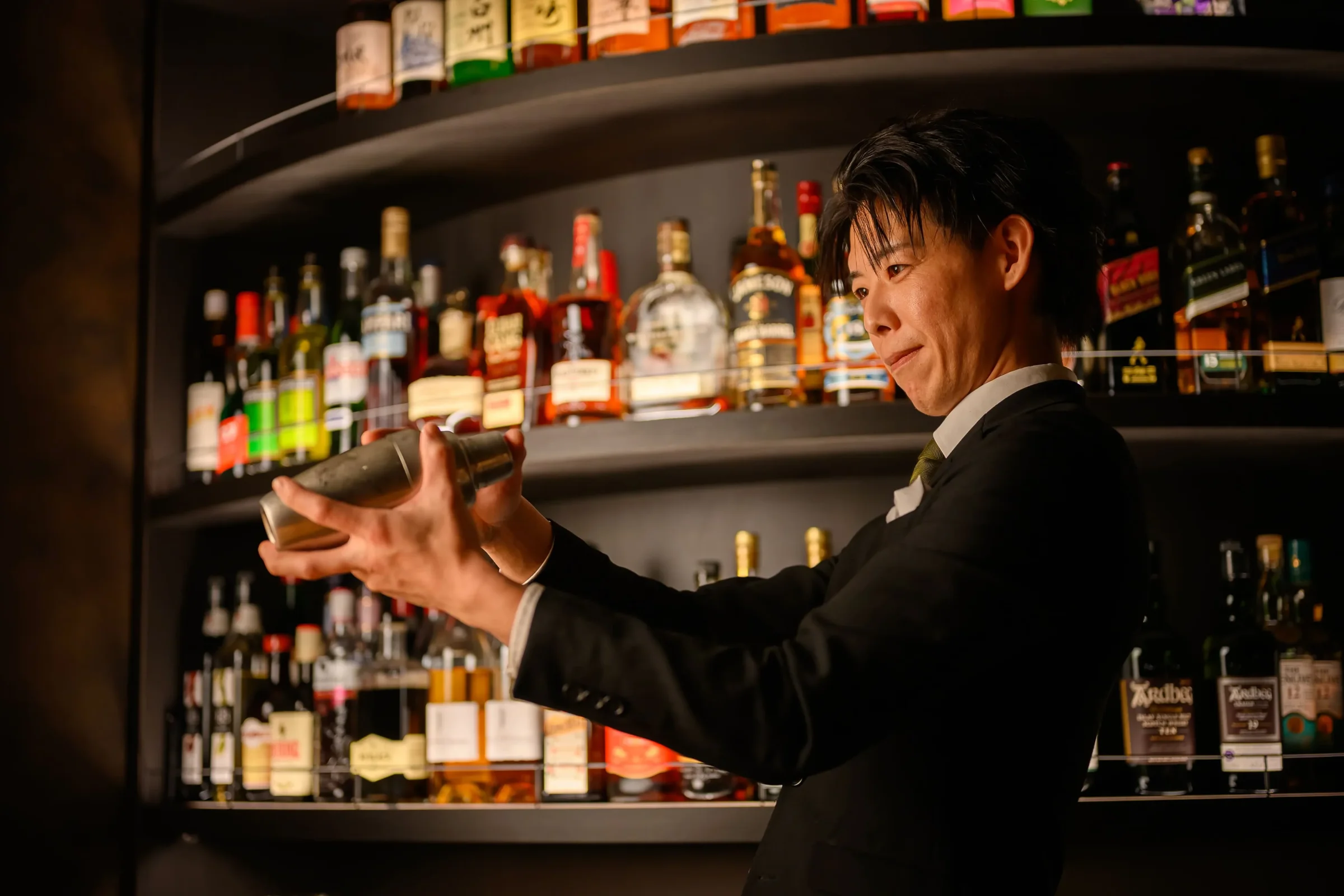 bar POSHのカウンターでカクテルを作るバーテンダー